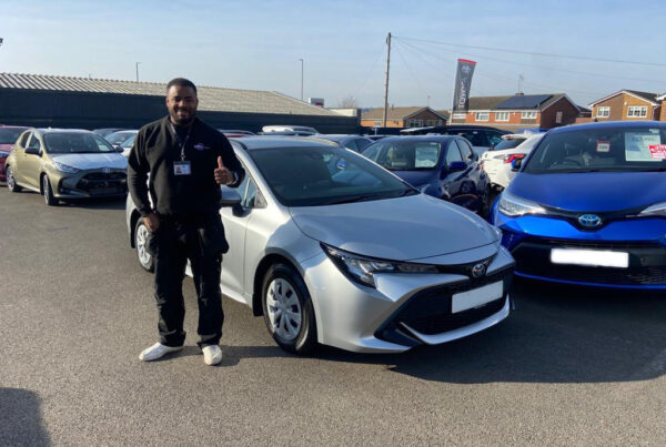 successful car sourcing for a customer, customer standing by his new car